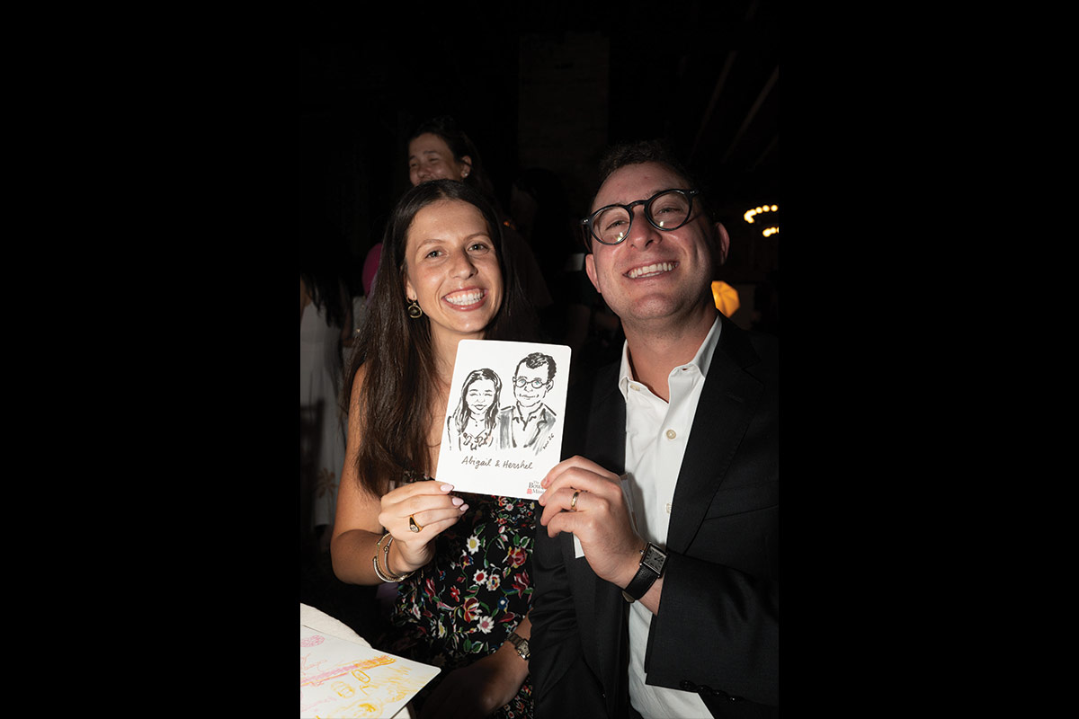Two guests holding their illustration